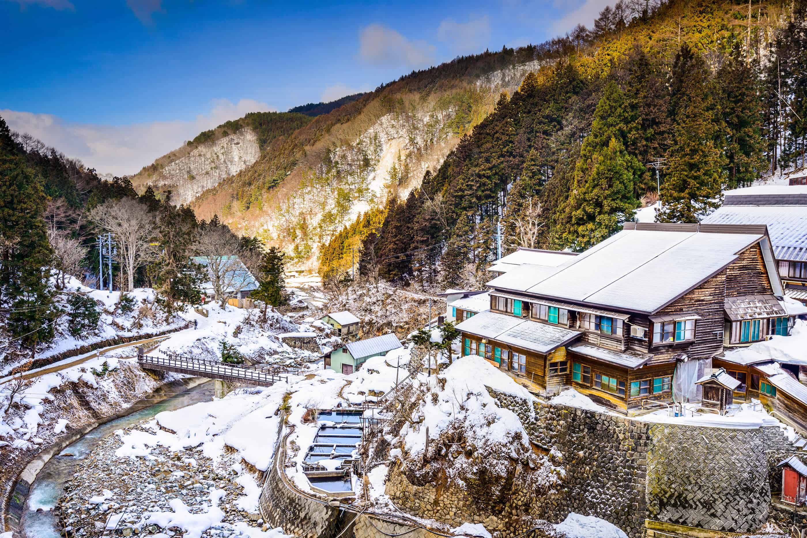 Nagano Japan Yudanaka Valley in winter. The buildings and ground is covered in a light blanket of snow.