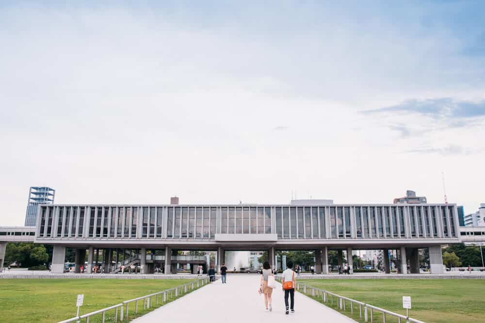 Hiroshima Peace Memorial Museum with people walking down a path towards it.