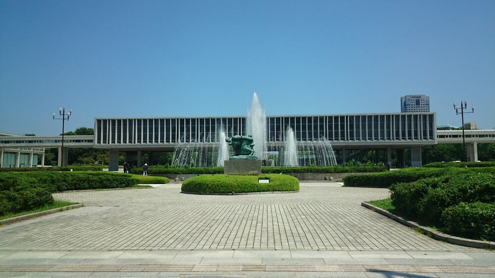 Hiroshima Peace Memorial Museum with a statue and water fountain in front of it.