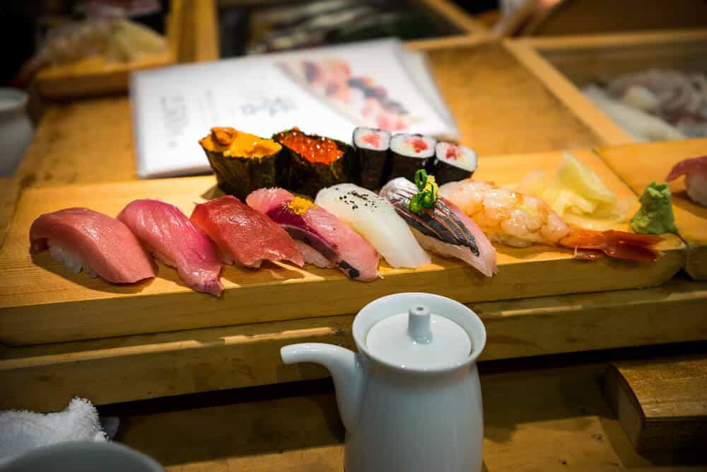 An assortment of fresh Sushi on a wooden serving counter.