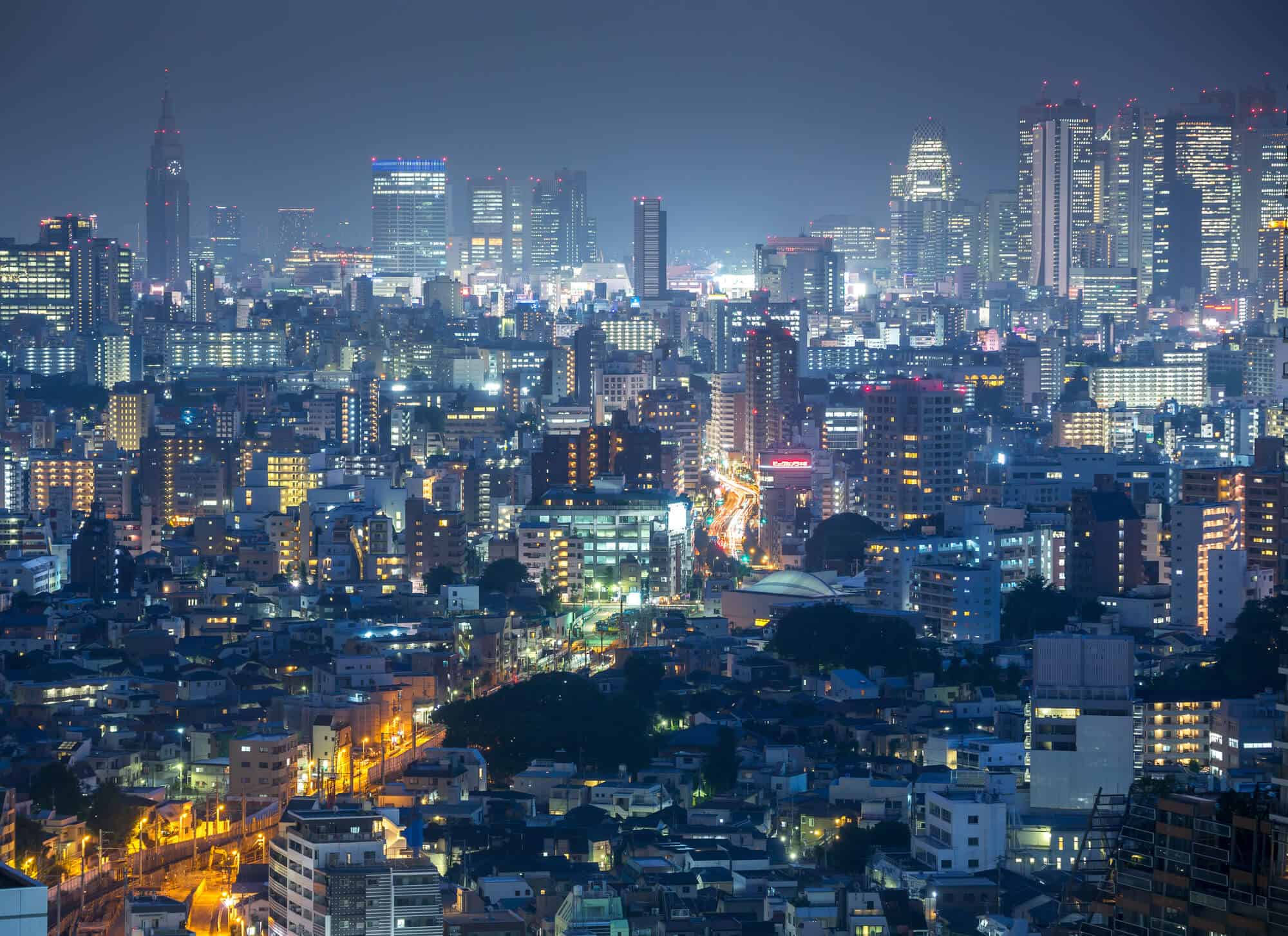 Shinjuku at Night with a sea of huge buildings everywhere. There are buildings with their lights on for what seems like miles and miles.