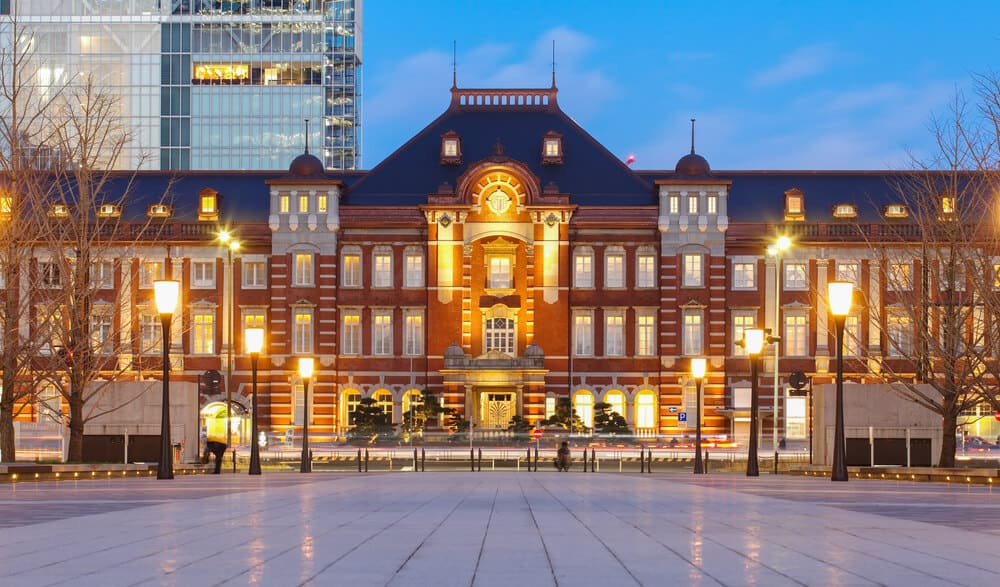The outside of Tokyo Station, with the street lamps lit up.