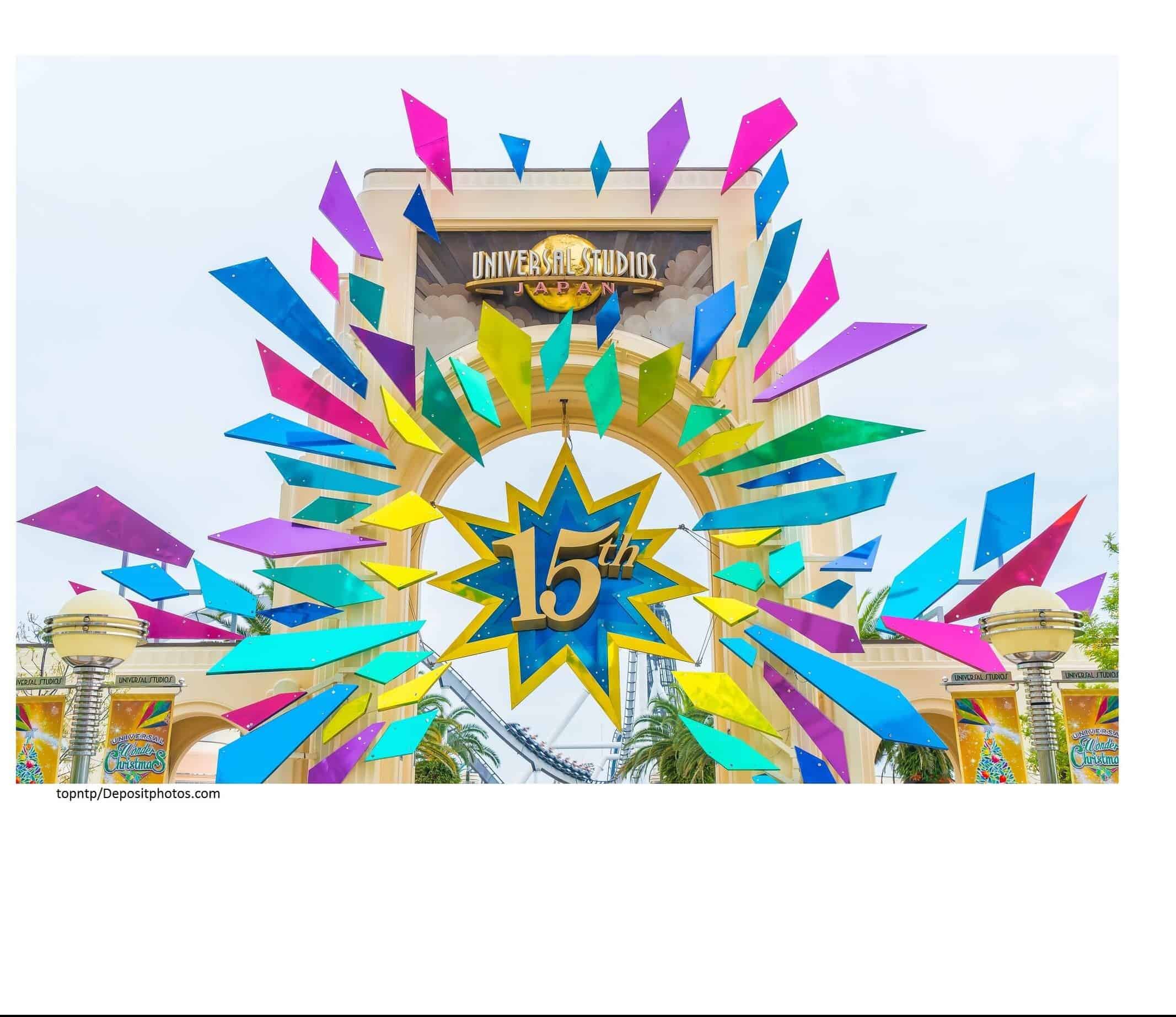 An entrance gate that is displaying the sign "Universal Studios Japan" with a "15th" decoration hanging from it.