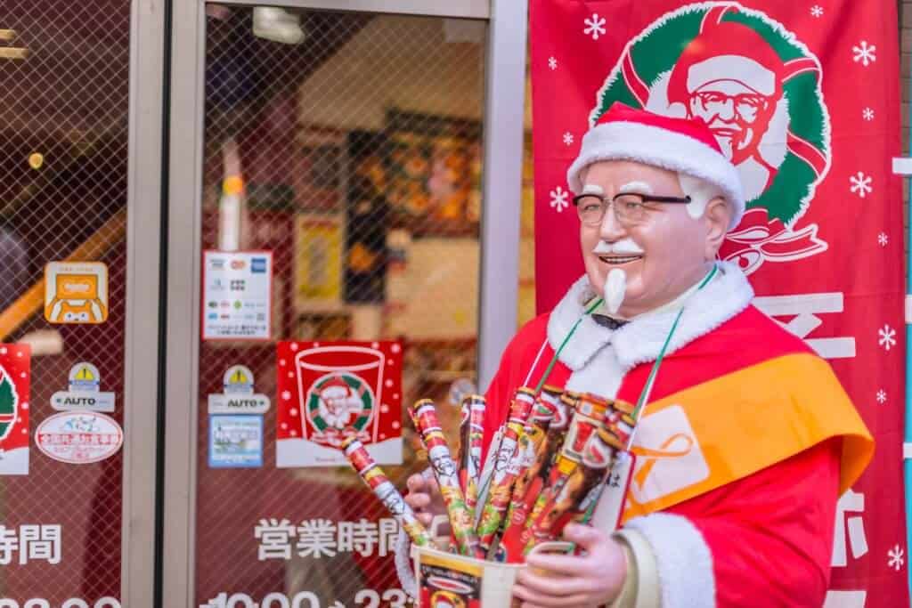 Christmas in Japan KFC - A photo of a Kentucky Fried Chicken restaurant in Japan, with a Colonel Sanders statue outside.