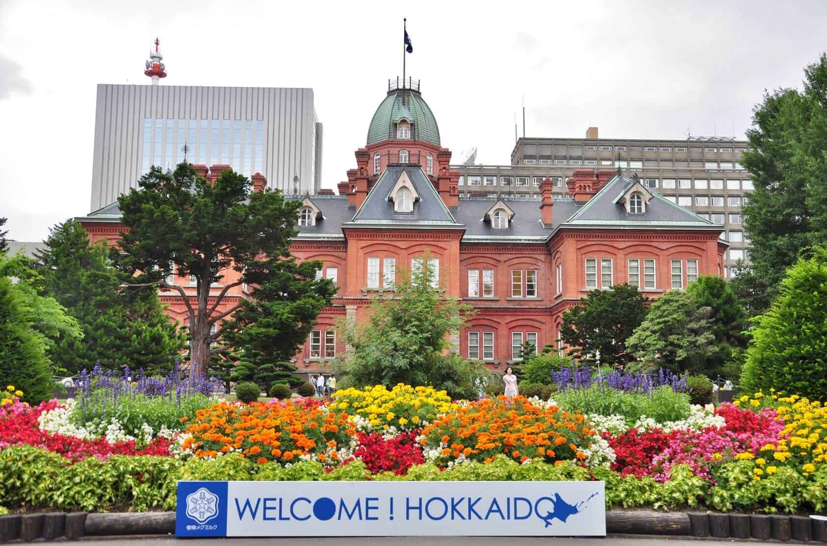 The front of the Old Government Building in Sapporo, with a sign in the front that says "WELCOME! HOKKAIDO"