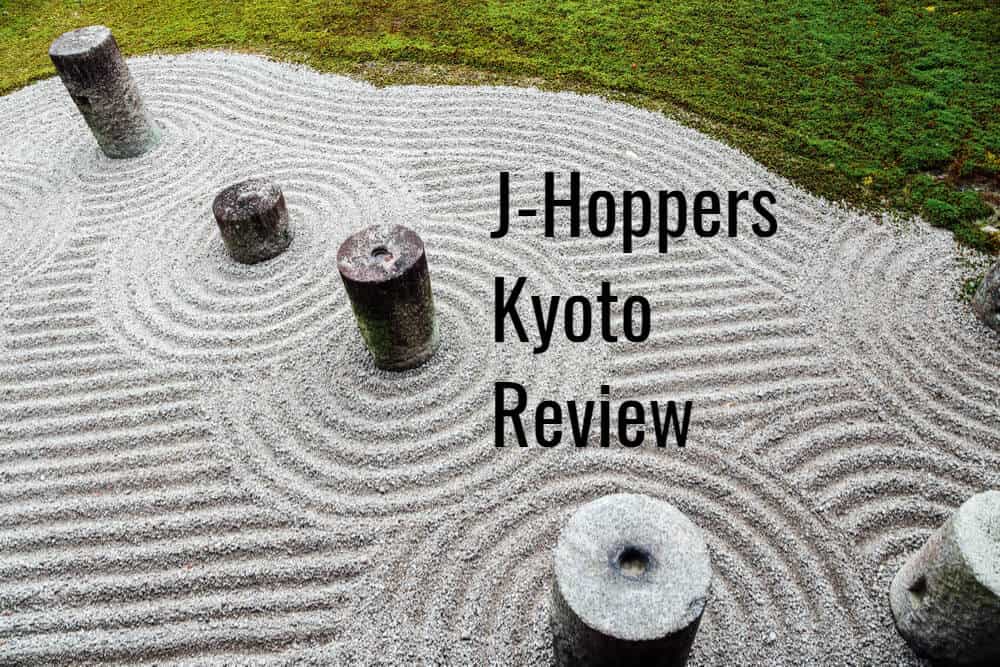 A Zen type of sand garden with stone pillars in it, and beatifully raked sand. The text in the image reads, "J-Hoppers Kyoto Review"