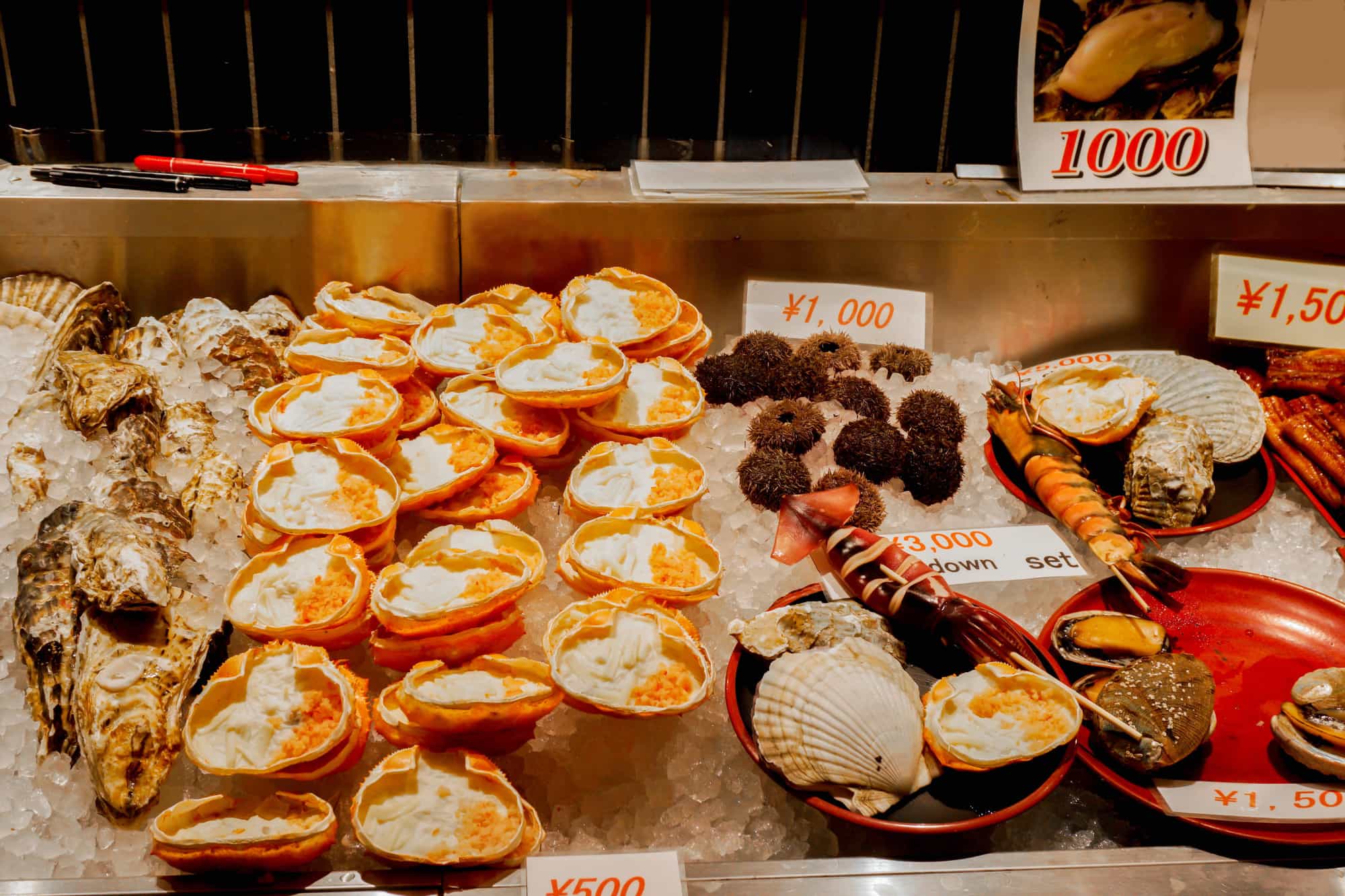 Fresh seafood is being displayed a food vendor's stall in Japan (crab, scallops, uni, shrimp, oysters.).