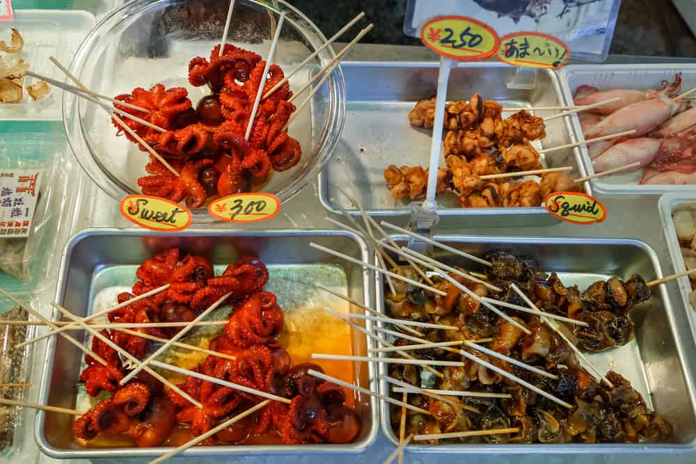 A shop at Nishiki Market that is selling seafood skewered on a stick. Squid and small octopi can be seen.