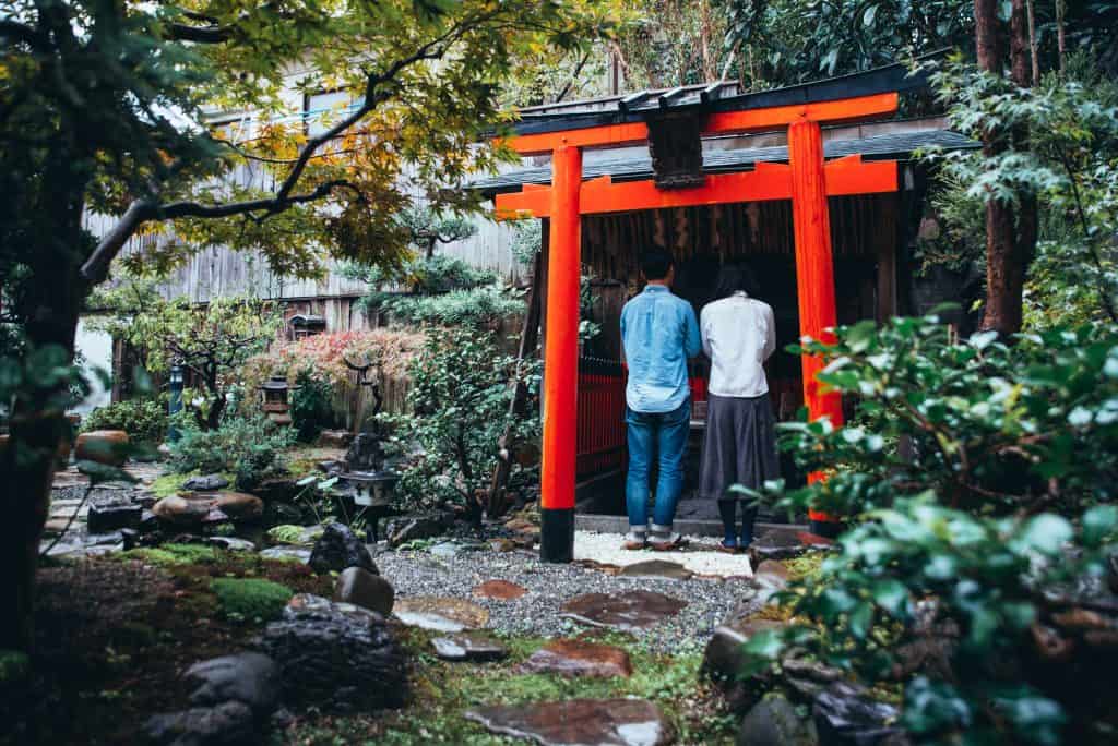 Praying at a small ShintoTorii Gate