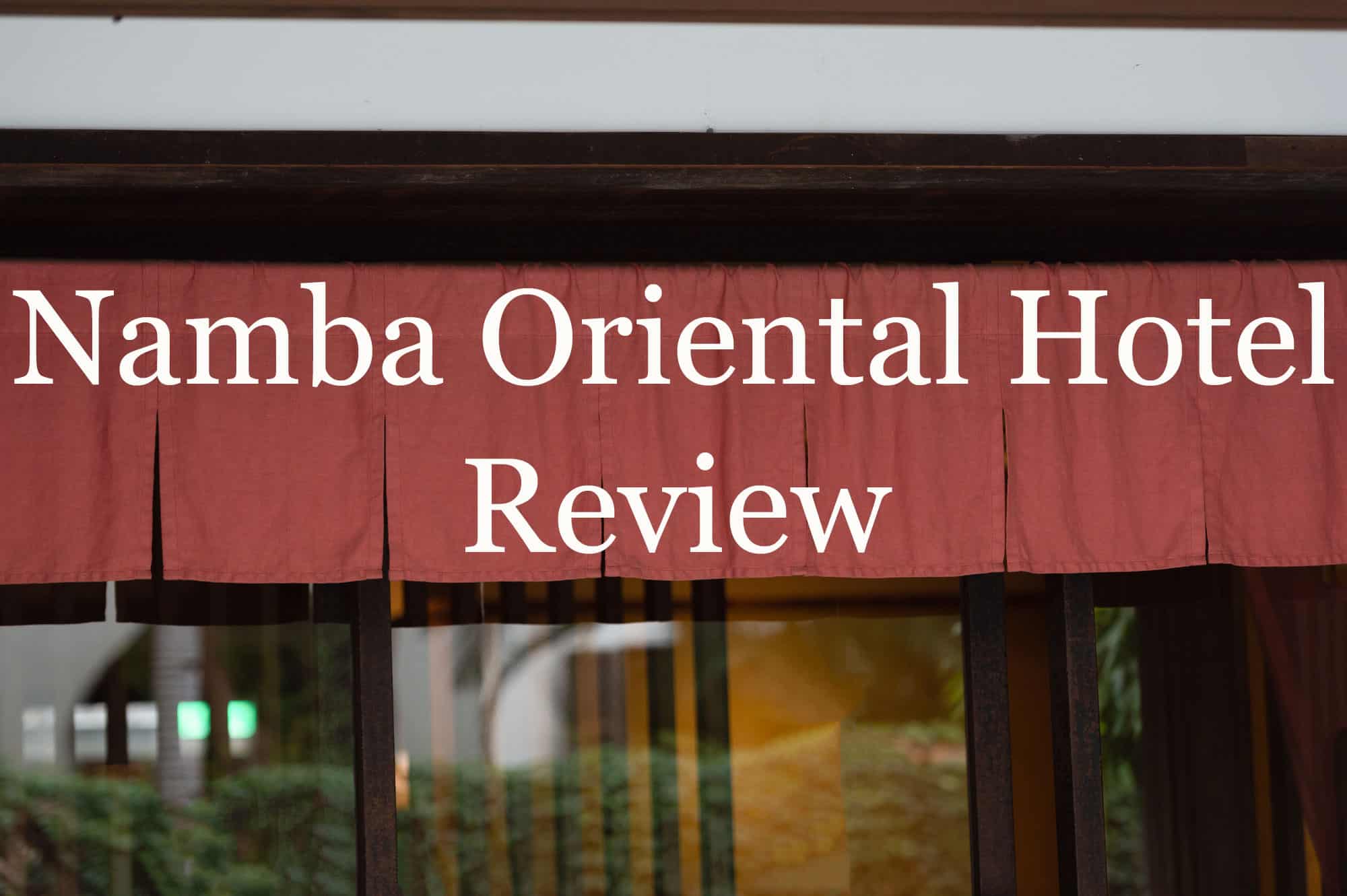 Red cloth hanging from a Japanese style door-front that says the title of this article, "Namba Oriental Hotel Review."