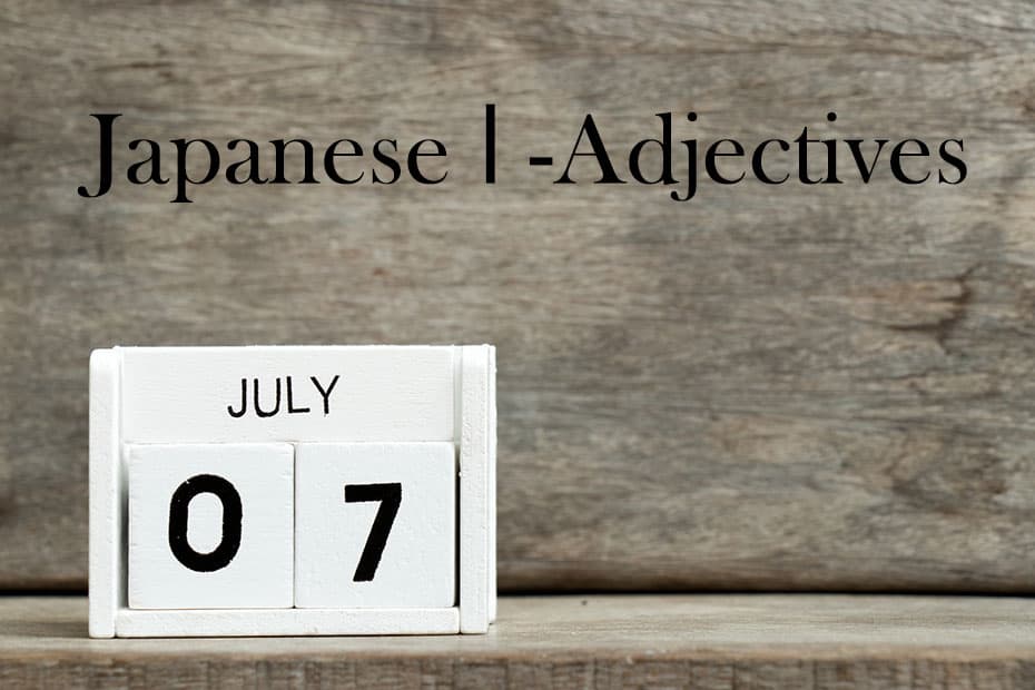 A white calendar showing the date of July 07. It is on a wooden surface, which is the same as the background.