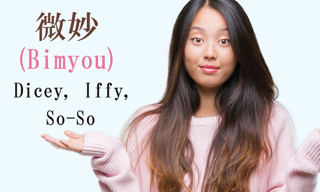 A picutre of a young, Asian girl wearing a pink sweater putting both of her hands up while shrugging her shoulders. Japanese characters and English translate to "Bimyou - Iffy,-Subtle" are written on the left side of the image.
