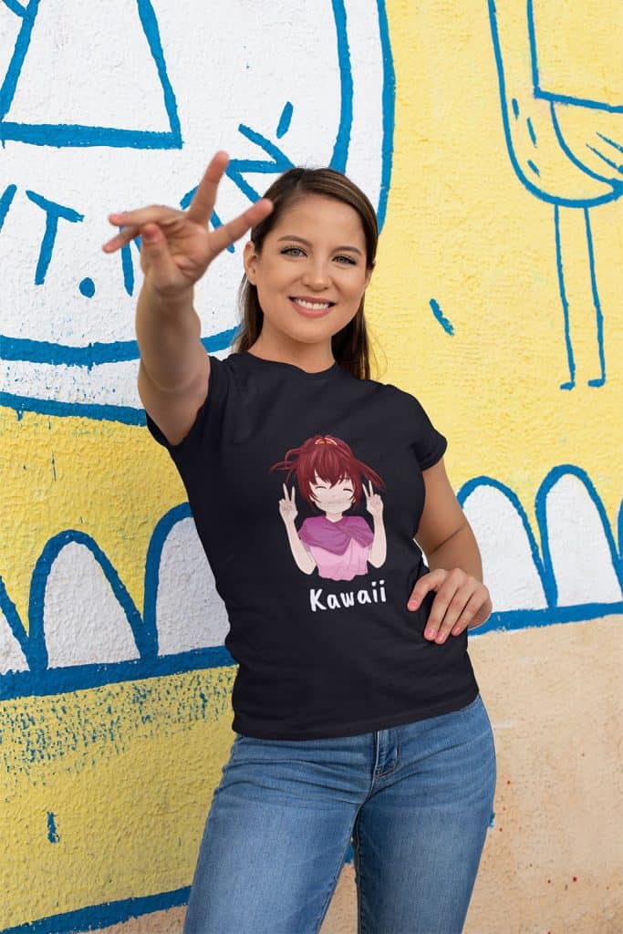 A young woman showing a peace sigh with her right hand, wearing a black shirt with a cute girl character on it. The character on her shirt is also showing the peace sign with both of her hands, and the text, "Kawaii" is written below it.