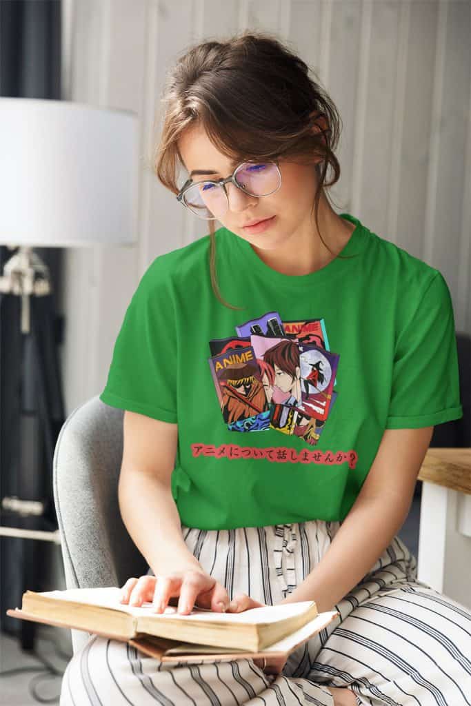 A young girl with glasses reading a book wearing a green shirt with illustrations of anime titles, and Japanese text. The Japanese text translates to, "Let's talk about anime." on it.