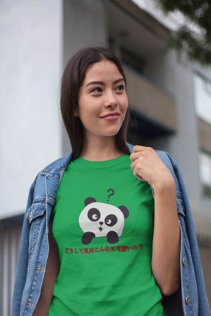 A young woman wearing a greet shirt with a panda character in the middle, with some Japanese text that translates to, "Why am I so cute?"