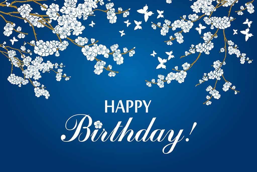 White butterflies and flowers on tree branches drawn on a blue background with the words "Happy Birthday" on the bottom in white text.