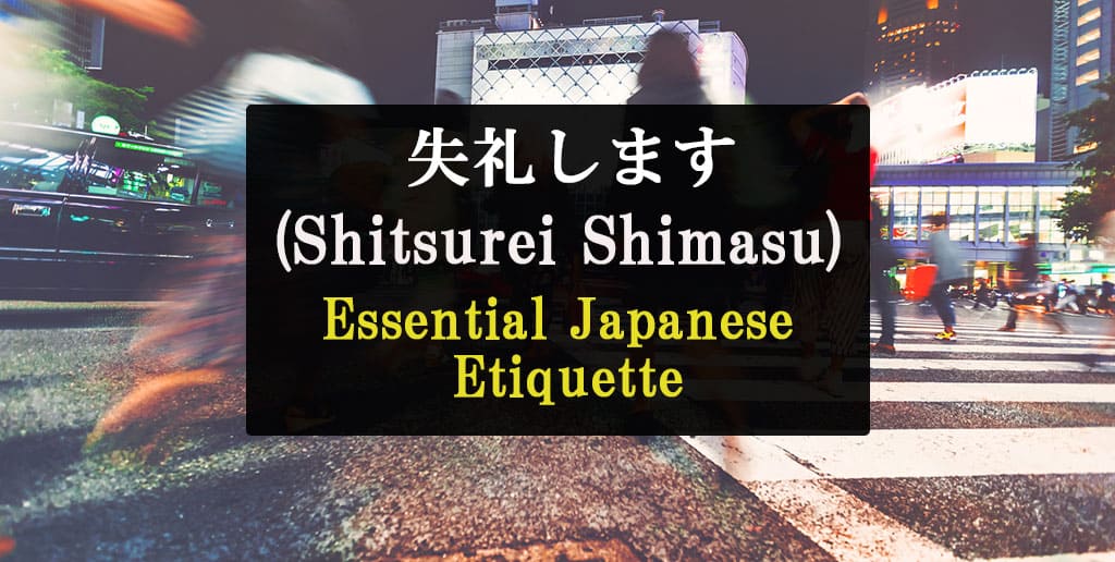 In the background, people can be seen crossing the street with a crosswalk in what appears to be Tokyo, but they are blurry. The foreground as text that reads, "Shitsurei Shimasu Essential Japanese Etiquette."