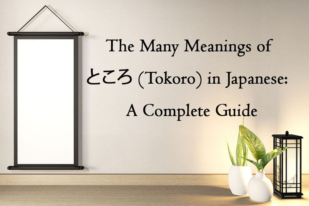 A hanging scroll with black borders is hanging on a white wall. In front of the wall on the ground is a small black lantern and two white vases with green, leafy plants in it. The text on this image reads, “The Many Meanings of ところ (Tokoro) in Japanese: A Complete Guide”